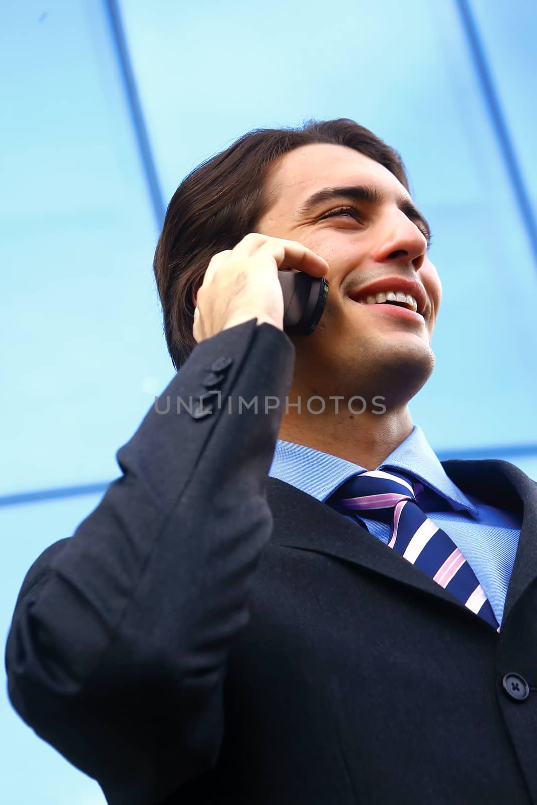 businessman speaking on the telephone against an office building 