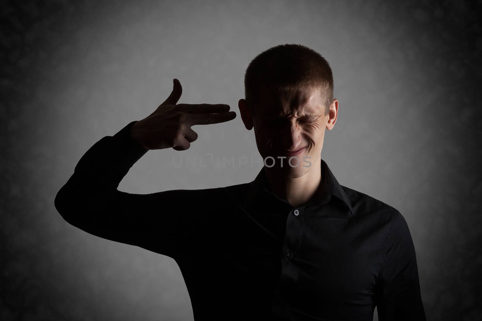 Frustrated young man put an imaginary gun to his head