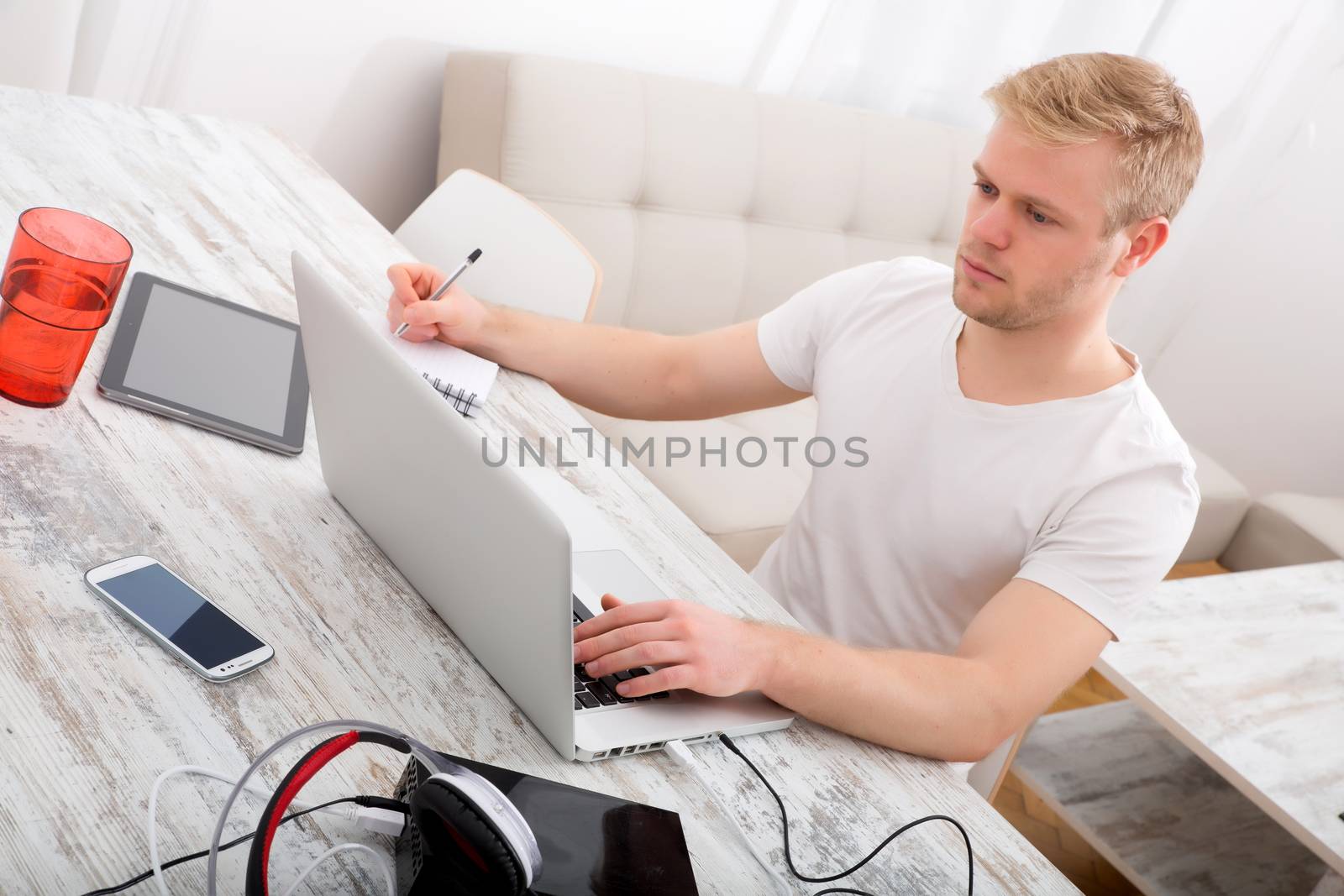 A young caucasian man working in his home office.