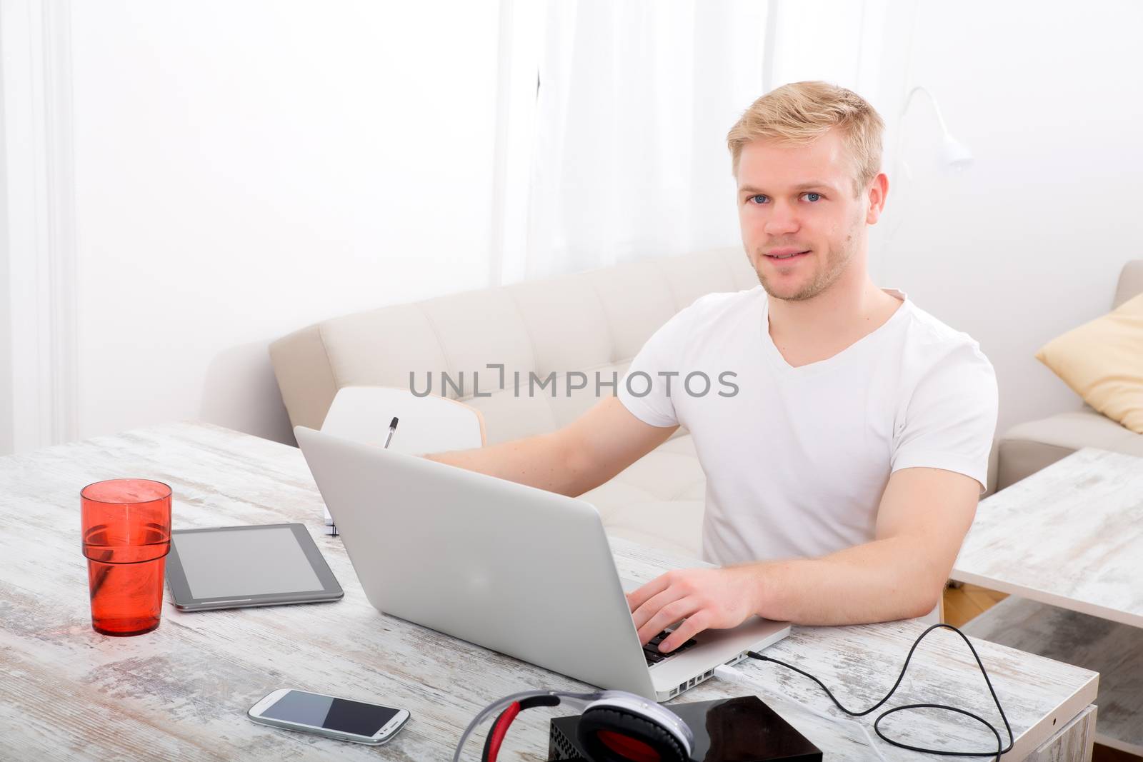 A young caucasian man working in his home office.