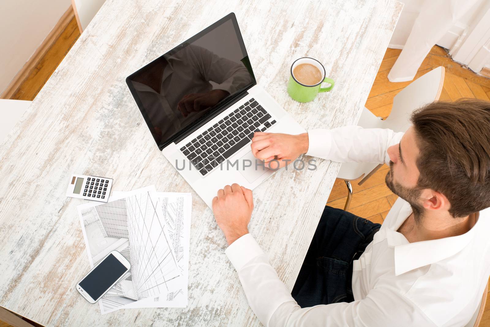 A young male architect working at home with a Laptop computer.