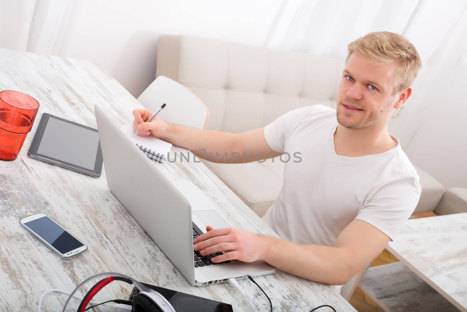 A young caucasian man working in his home office.