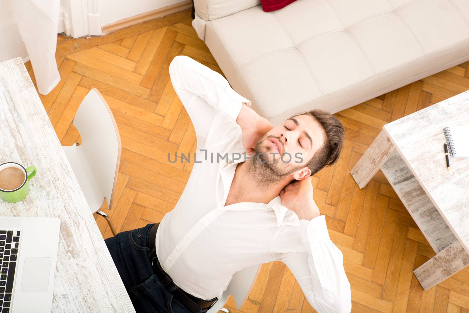 A young man working at home with a Laptop computer.