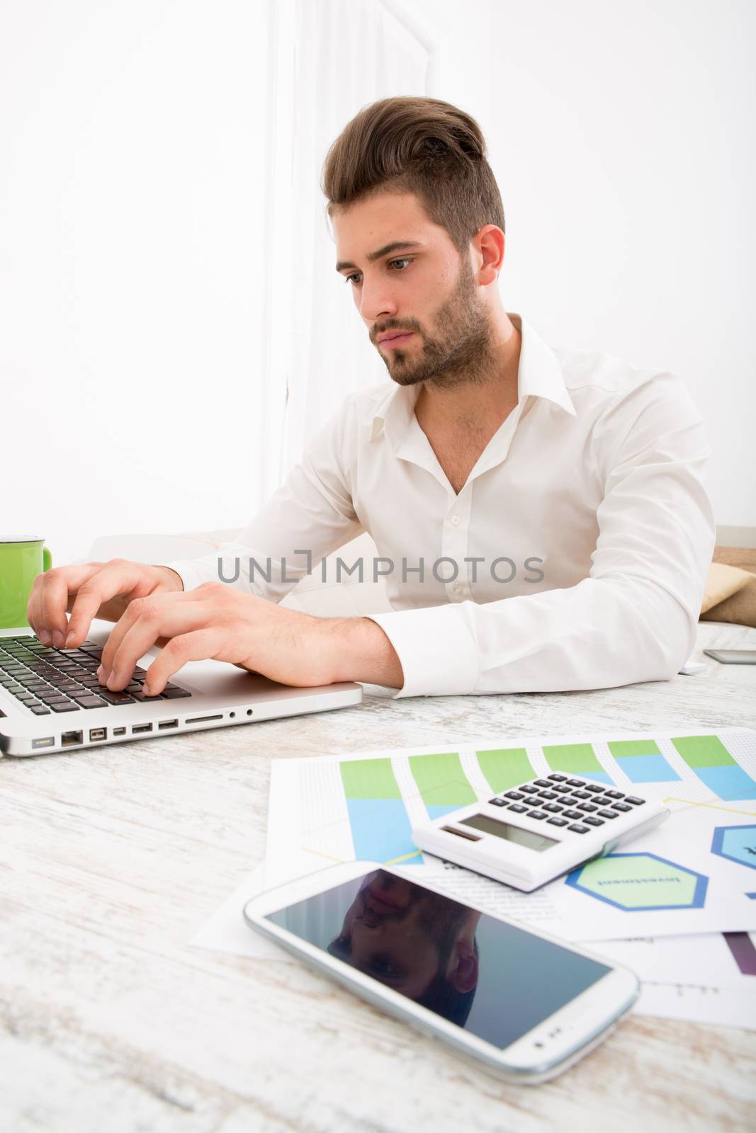 A young man checking his business statistics at home