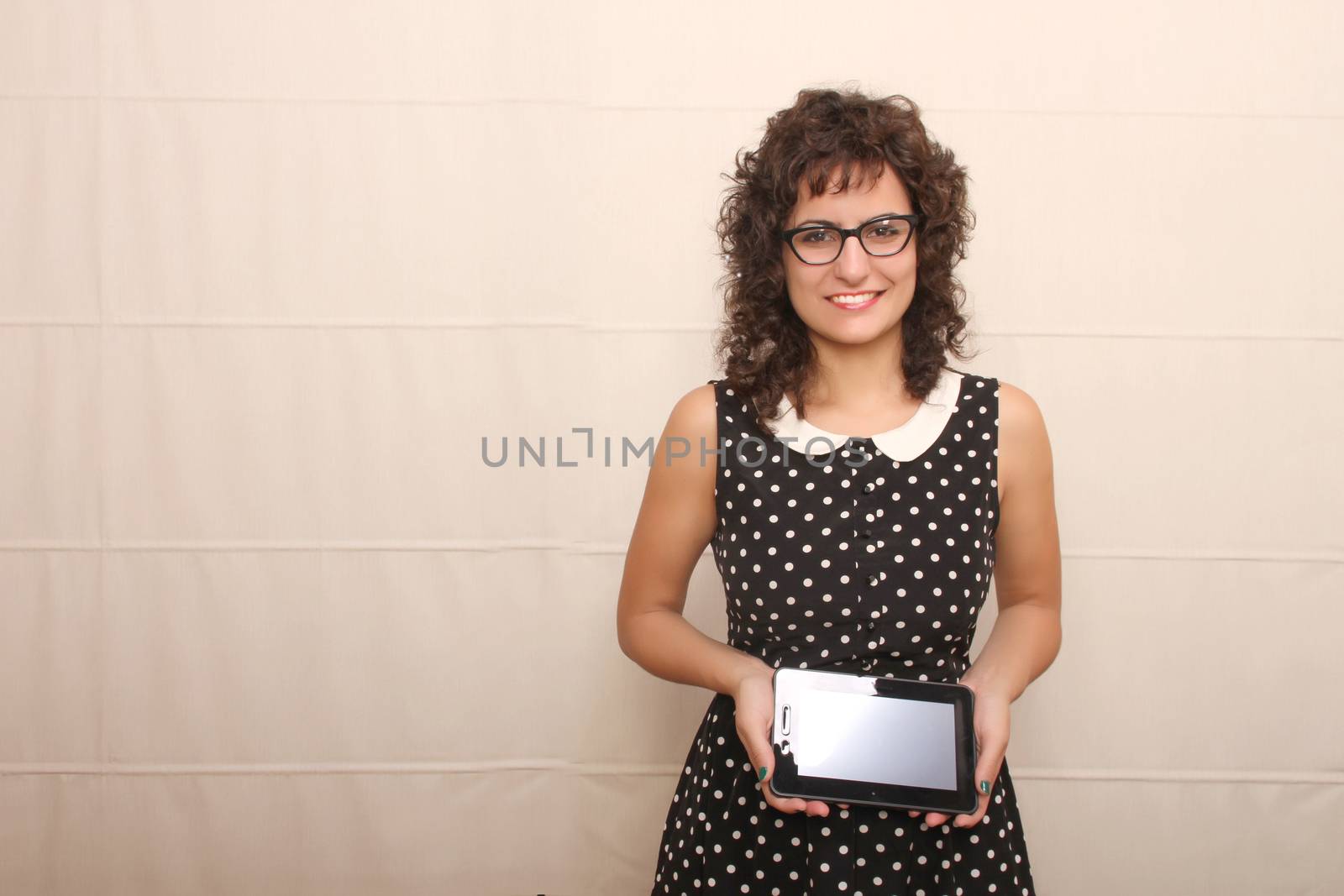 A young woman in a Retro dress holding a Tablet PC.