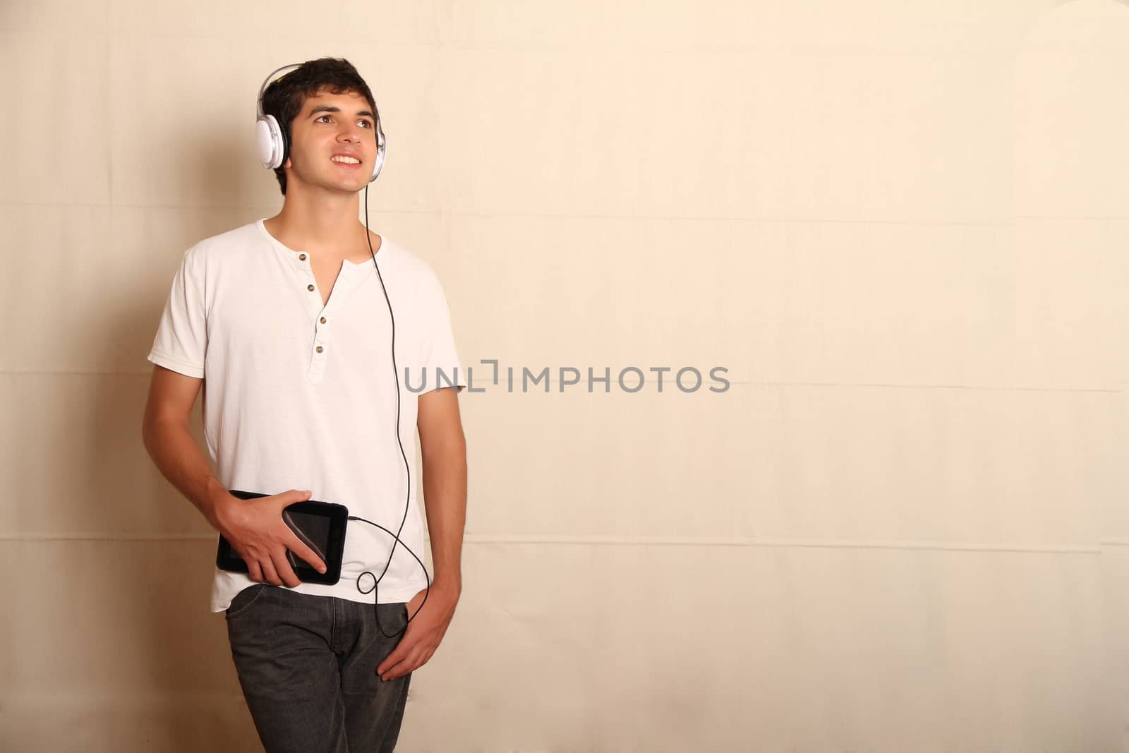 A young, latin man with a Tablet PC and headphones
