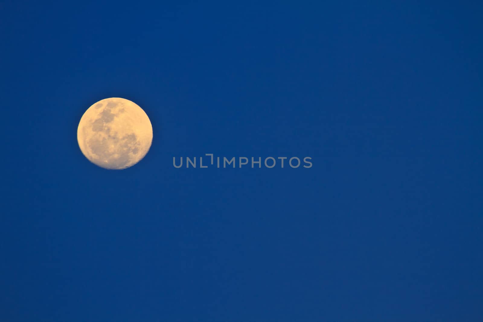 full moon in dark sky during the day