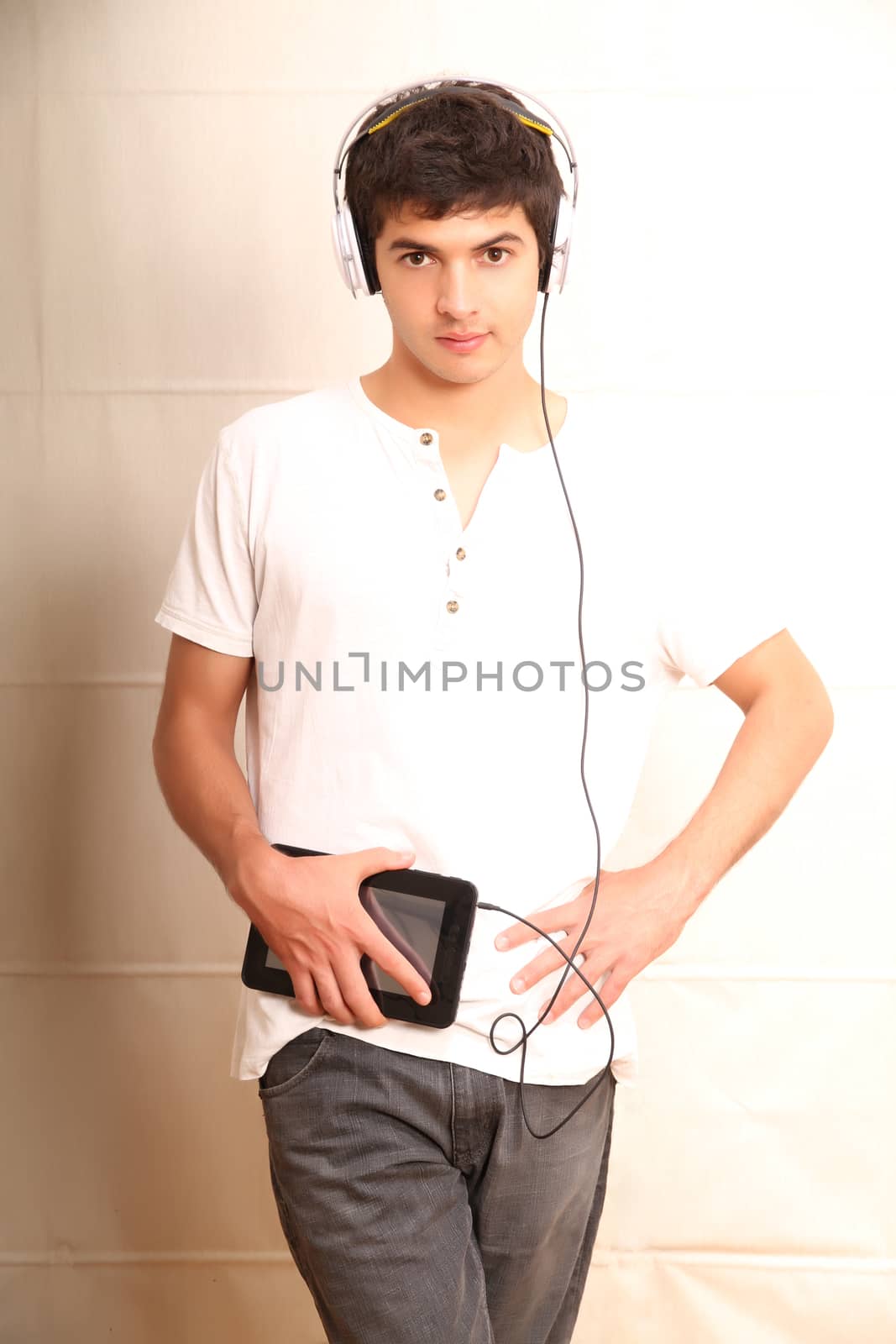 A young, latin man with a Tablet PC and headphones
