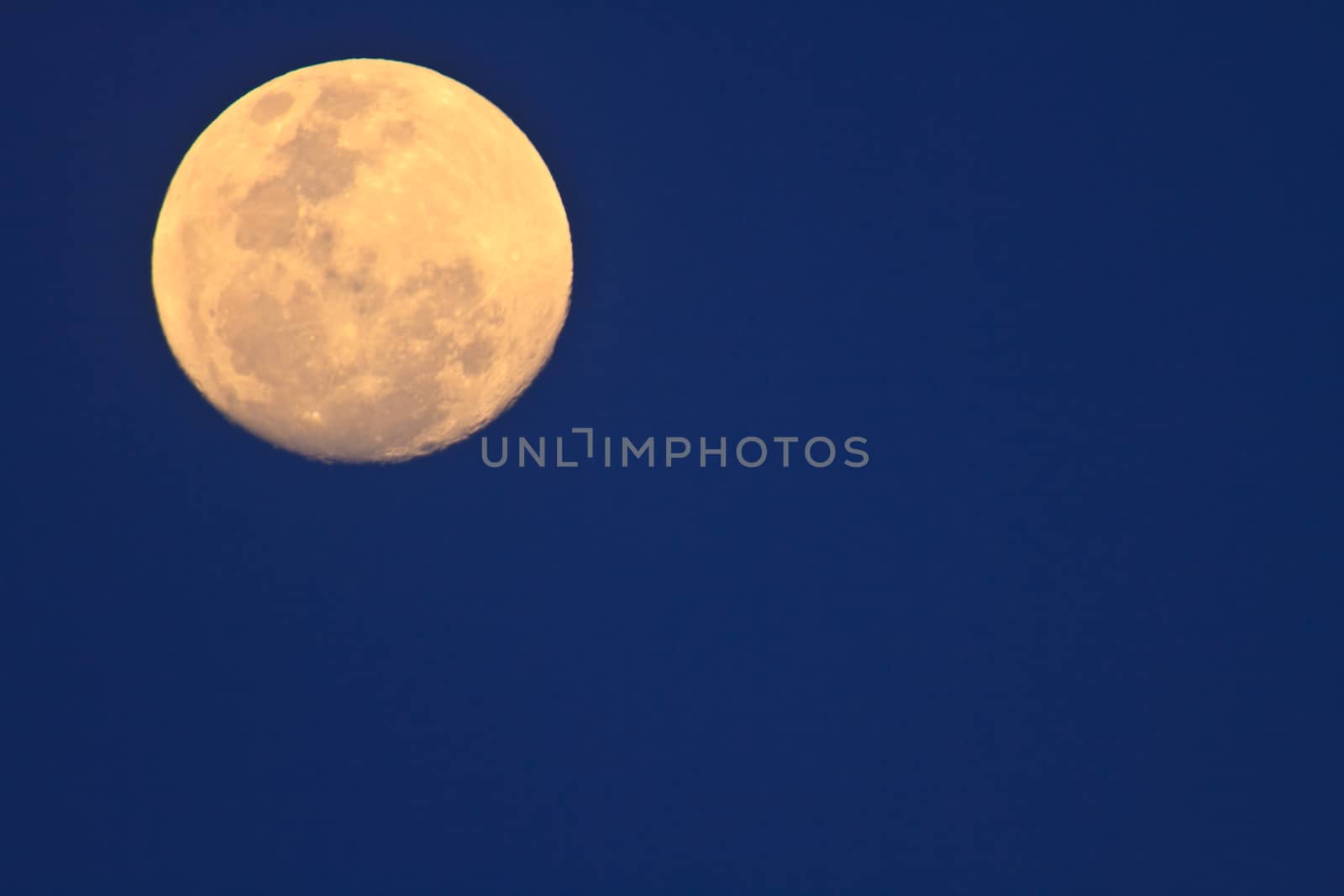 full moon in dark sky during the day