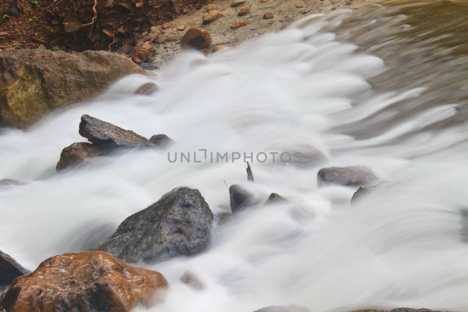 waterfall and rocks covered with moss in deep forest