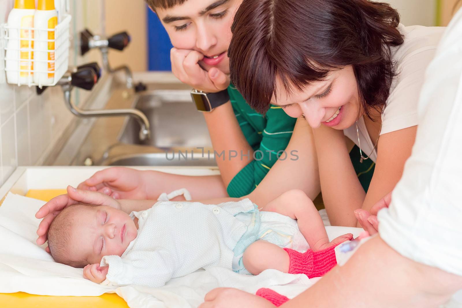 sleeping newborn baby in the hospital - the first hours of the new life, family looking to infant