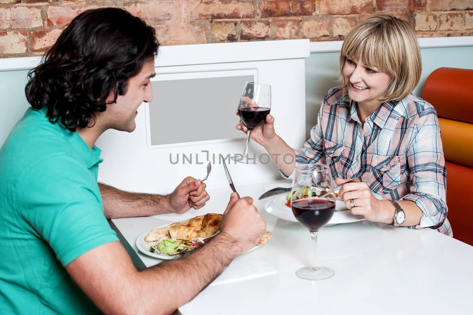 Couple enjoying dinner at a restaurant by stockyimages