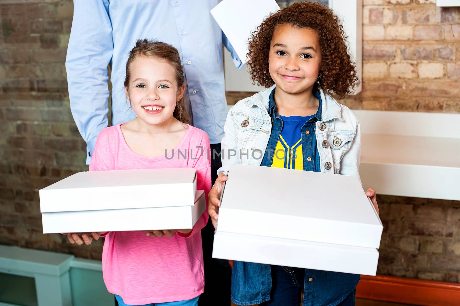 Attractive little girls posing with pizza boxes