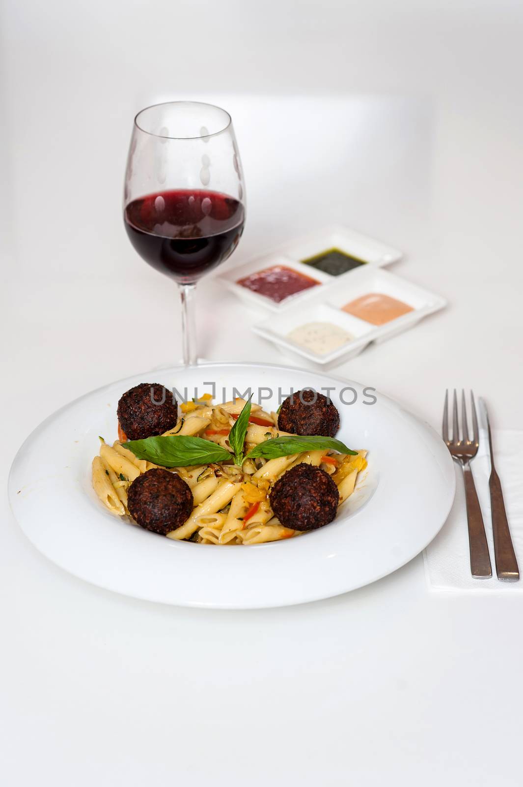 Yummy pasta served with red wine by stockyimages