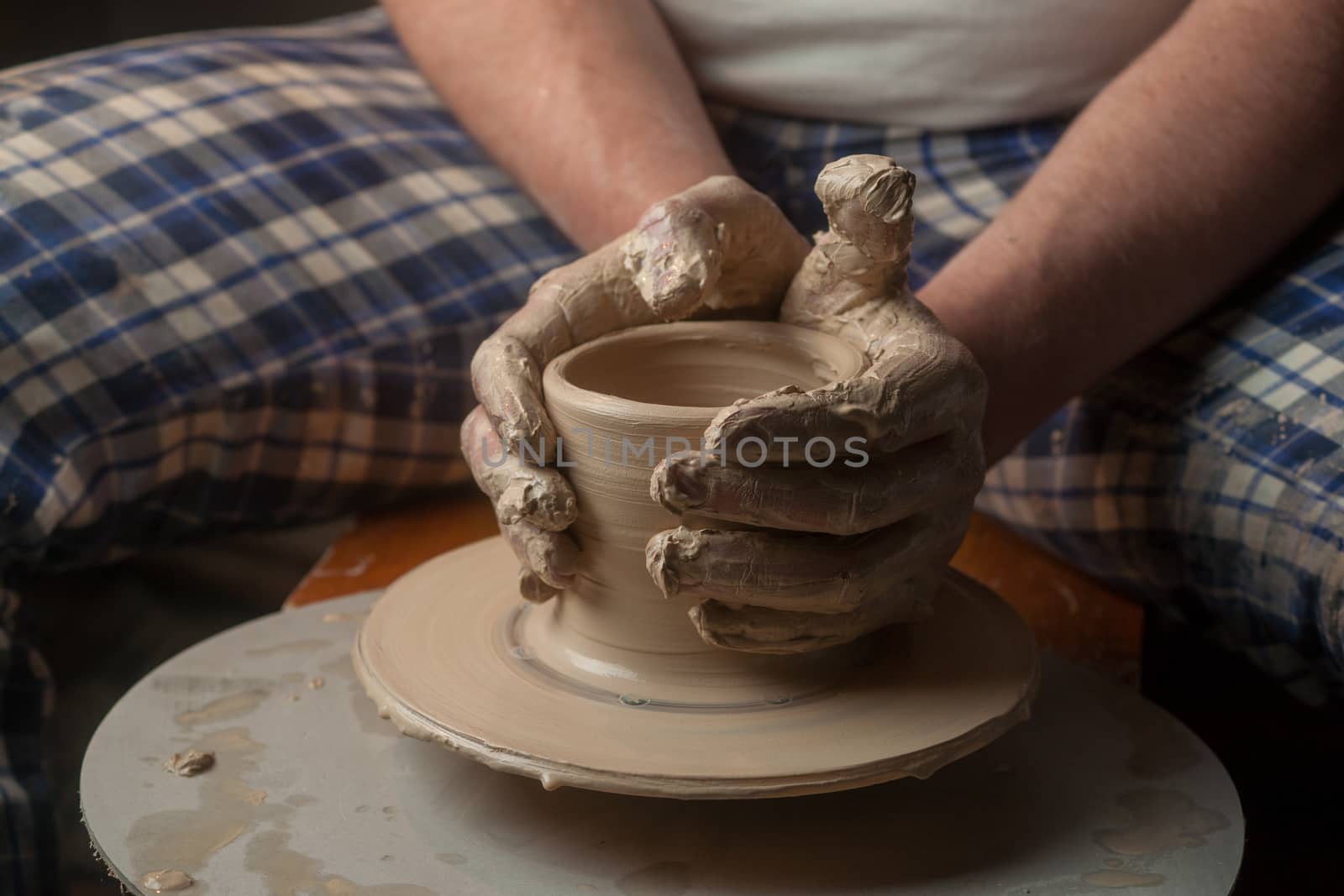 Hands of a potter, creating an earthen jar on the circle