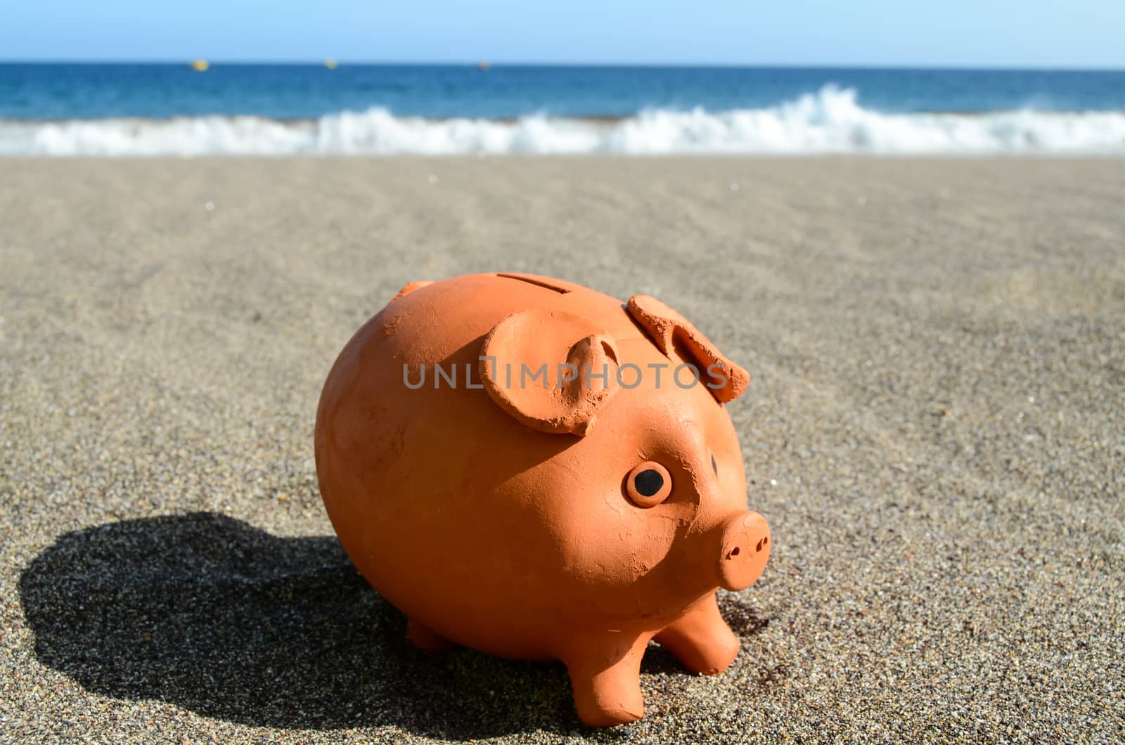 Piggy Bank on the Beach Saving for Vacation Concept