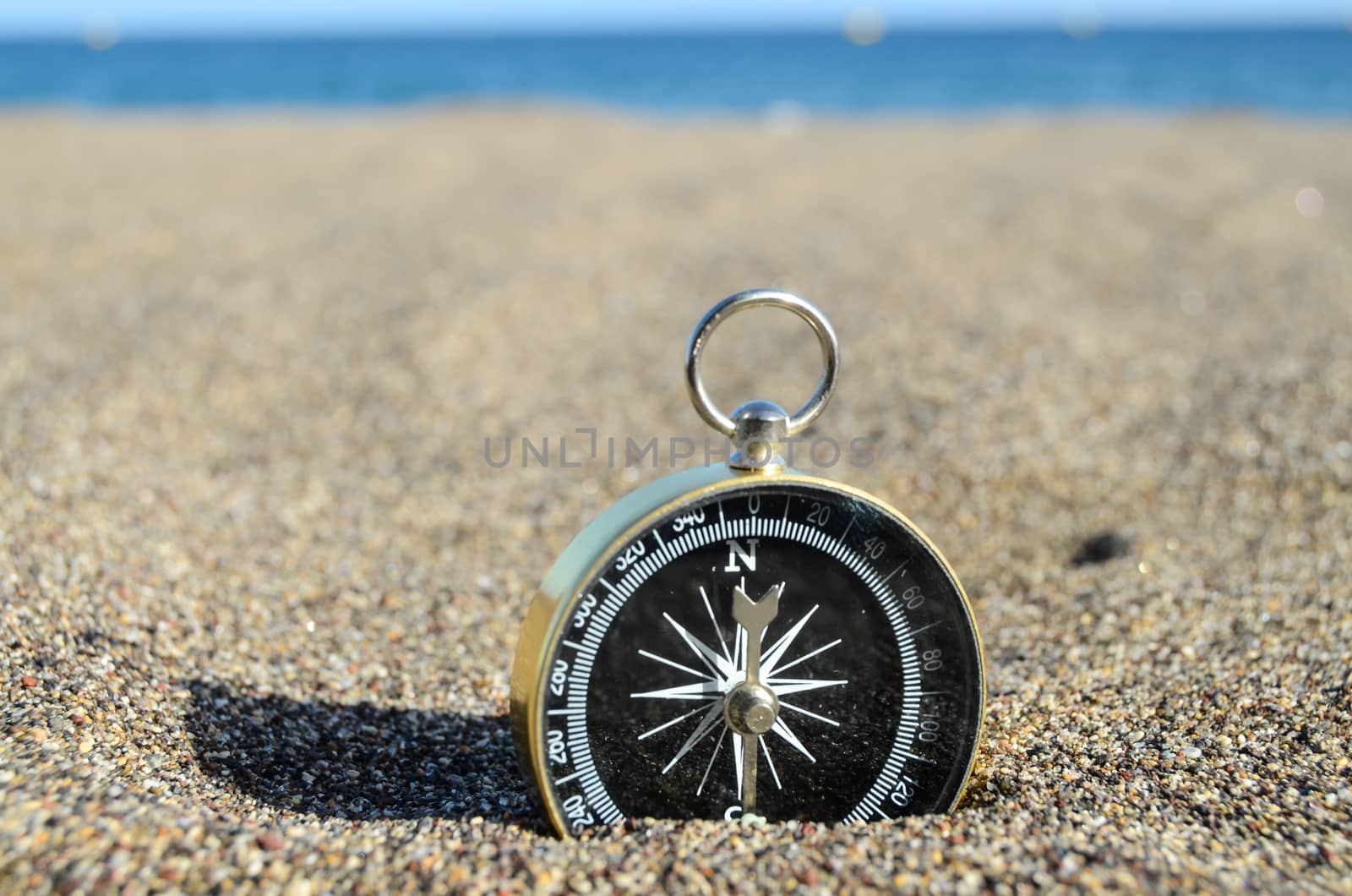 Orientation Concept One Compass on the Beach near the Atlantic Ocean