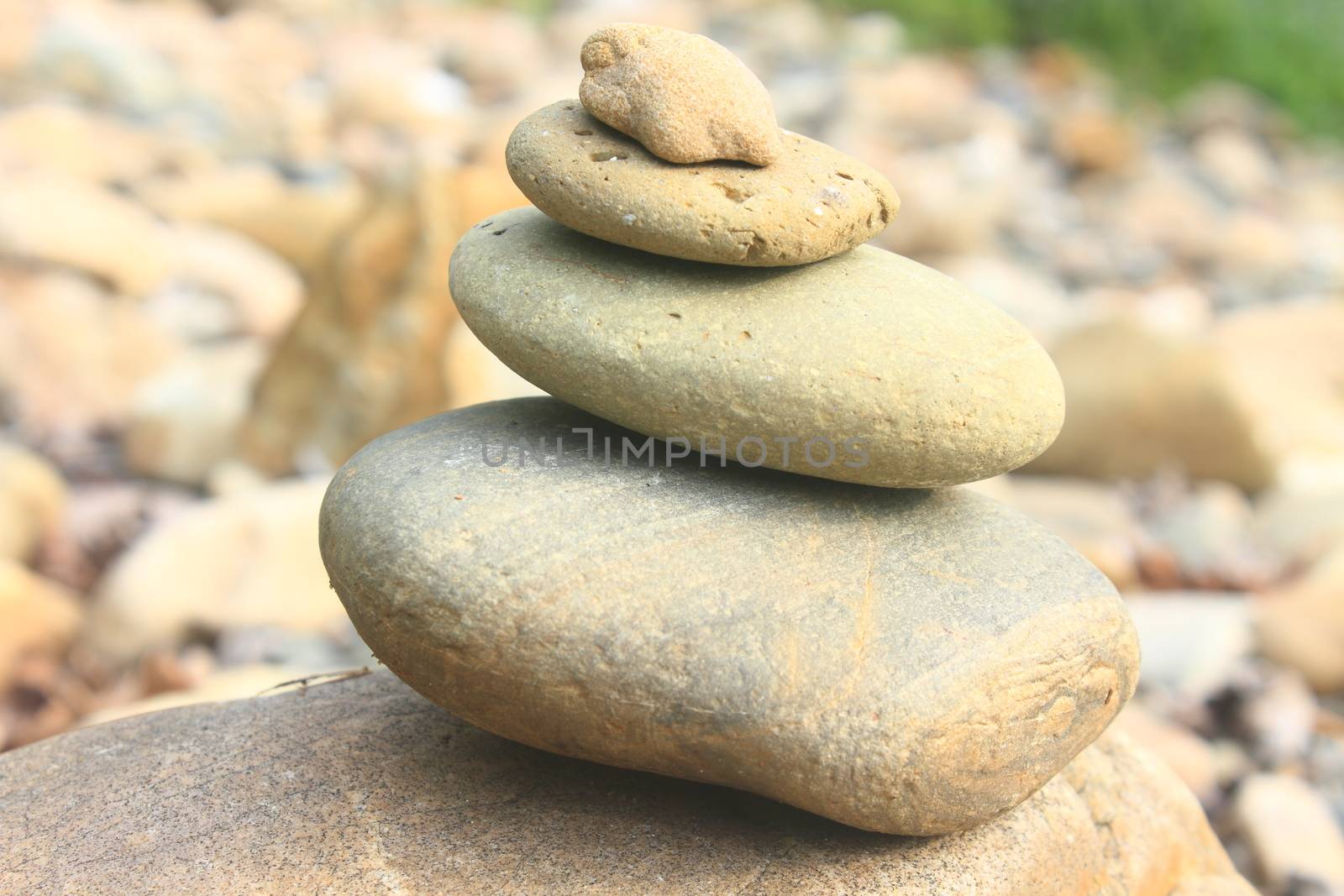 Stones pyramid near small river symbolizing zen, harmony, balance