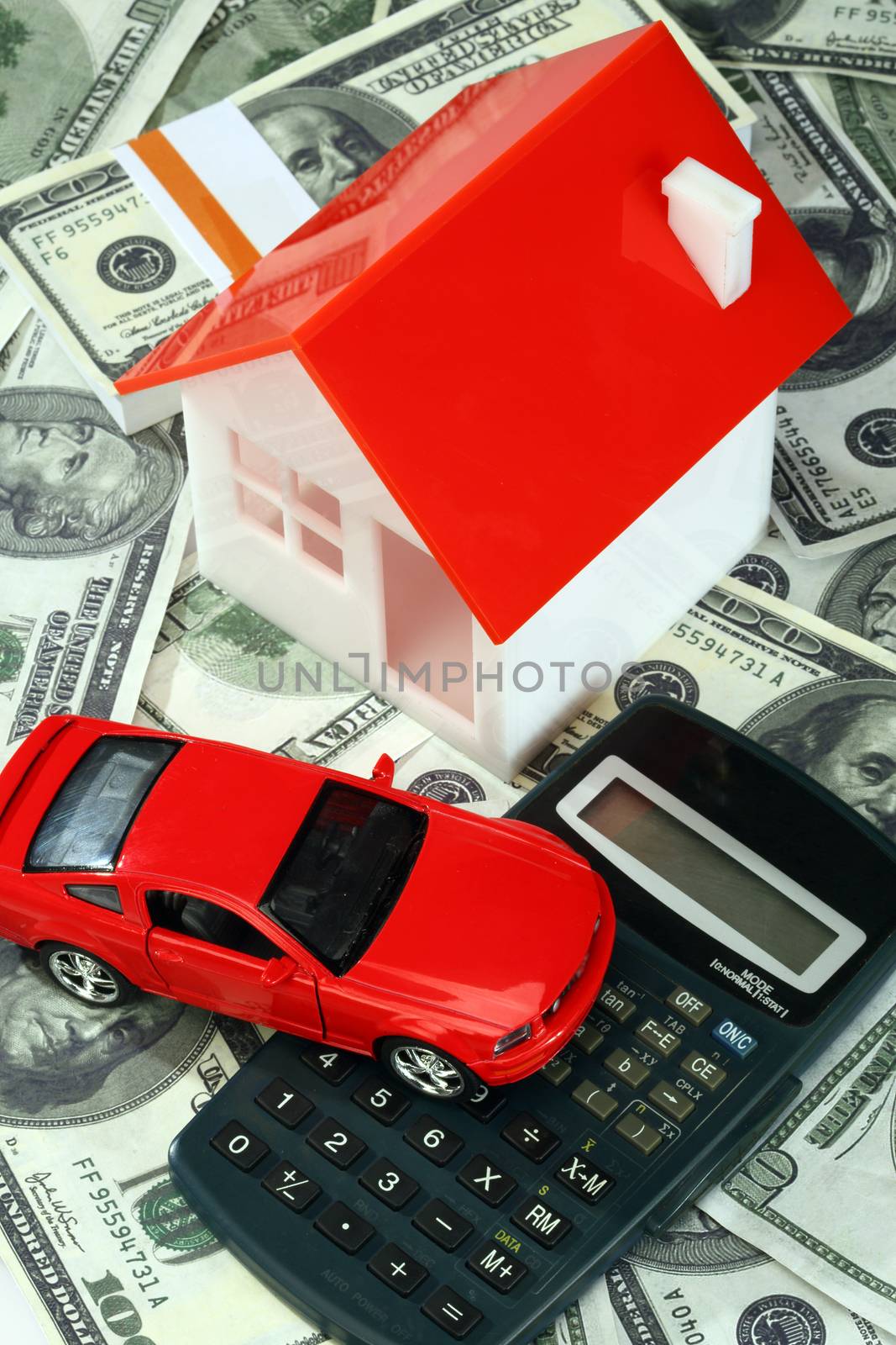 House, and car on top of a calculator and money