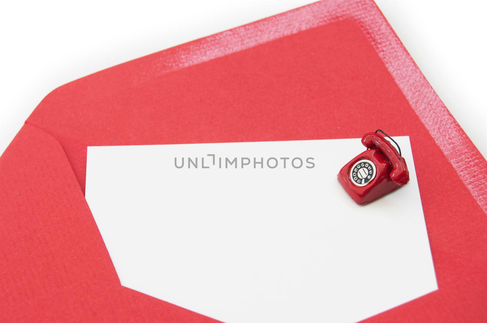 Blank business card inside an open envelope with a small phone on one side 