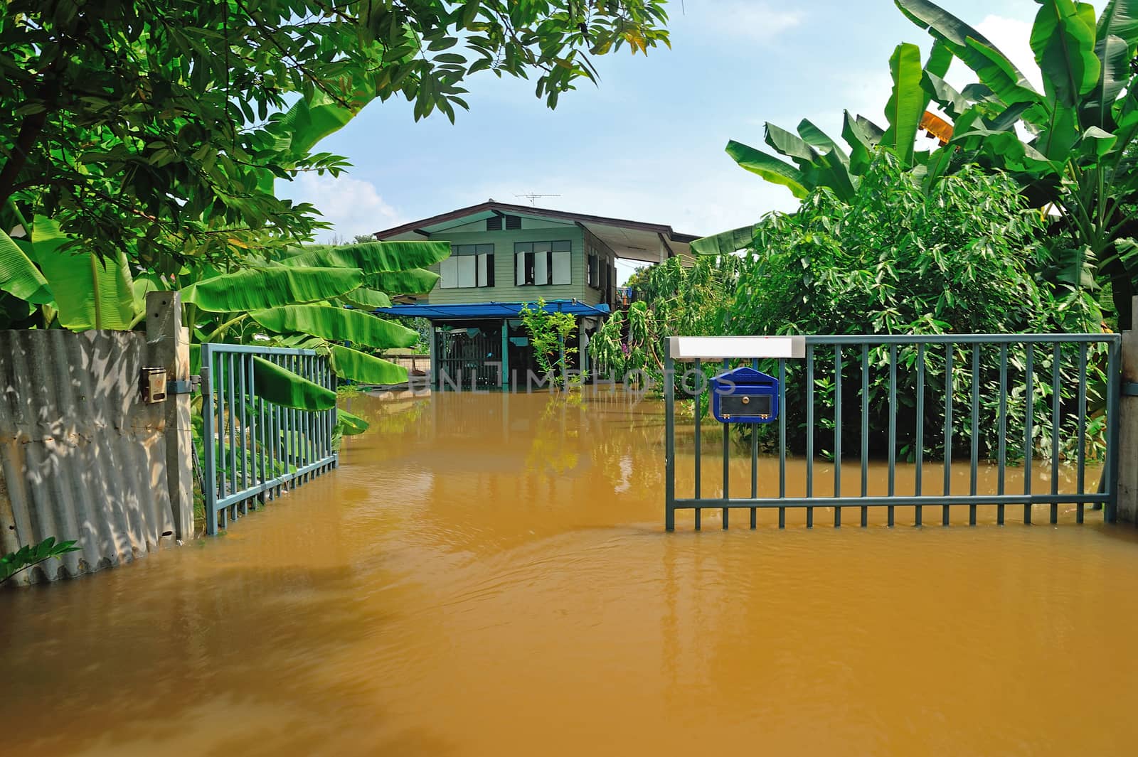 flood waters overtake a house in Thailand by think4photop