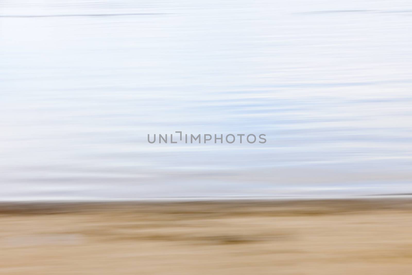 Background image of sand and water created by horizontal in-camera motion blur