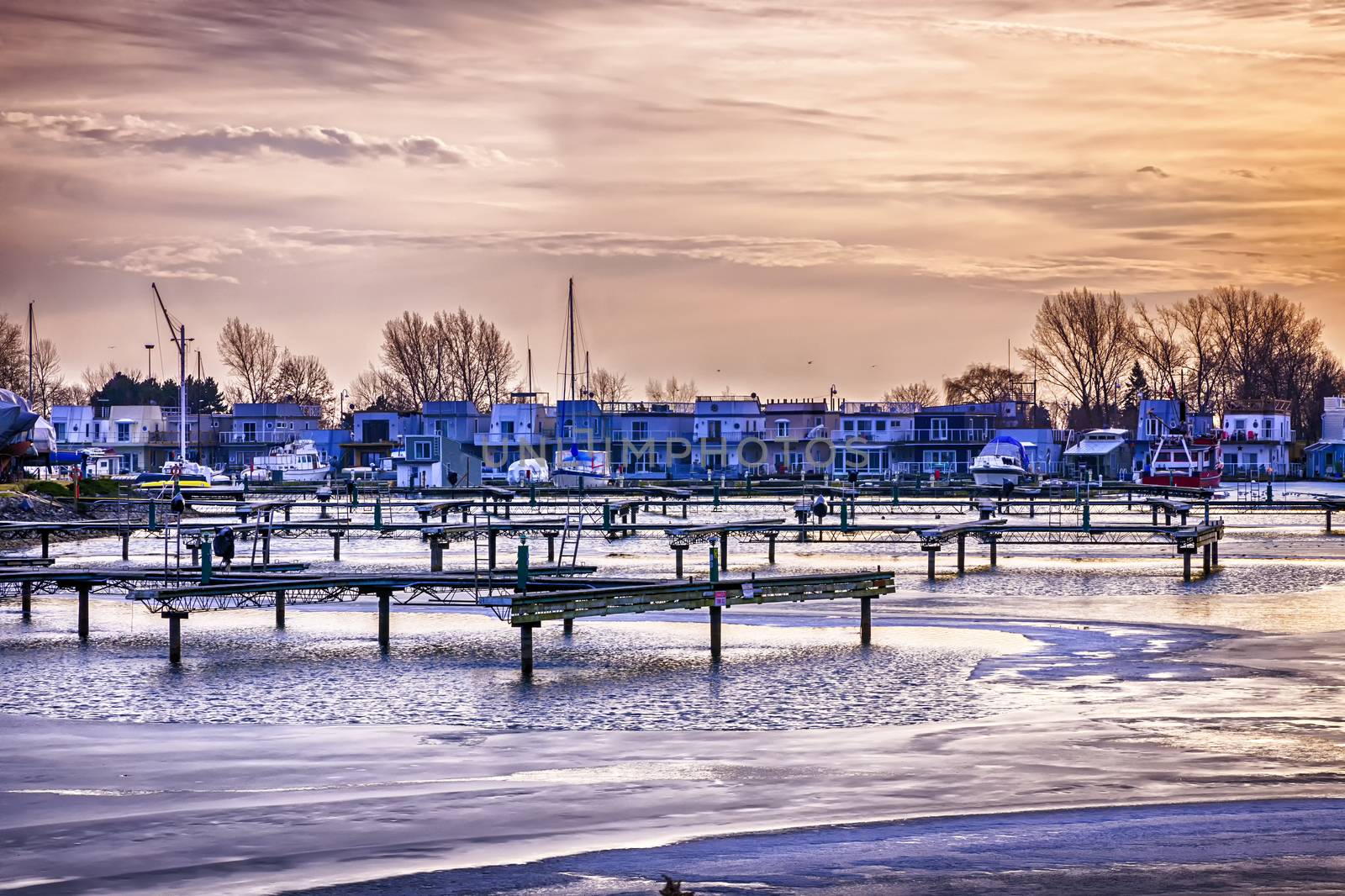 Sunset behind floating homes at Bluffers park marina in Toronto, Canada.  Winter.