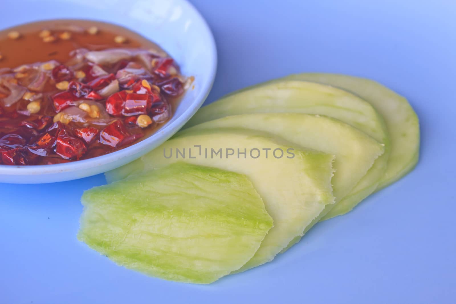 mangoes with sauce, mangoes dipped into a sweet fishy paste with dried shrimp and red onions in plate