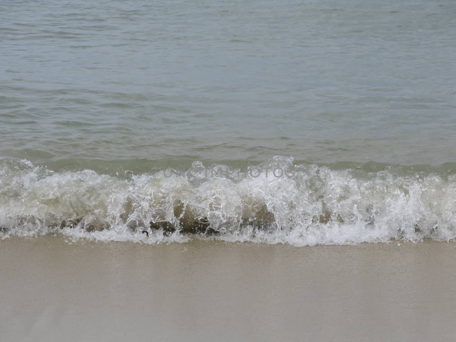 Wave on sandy beach, Mallorca, Balearic islands, Spain.