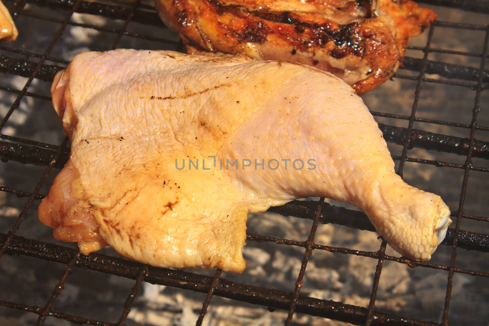 Grilled chicken thigh on the flaming grill