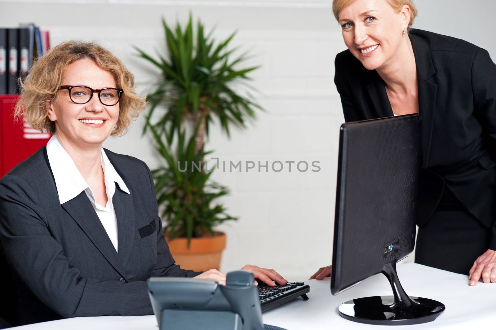 Businesswomen sitting in modern office by stockyimages