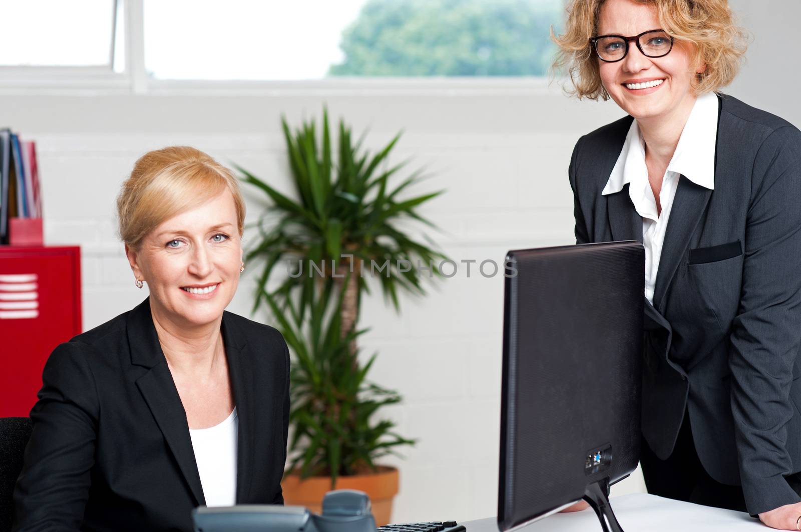 Joyful businesswomen enjoying at work desk