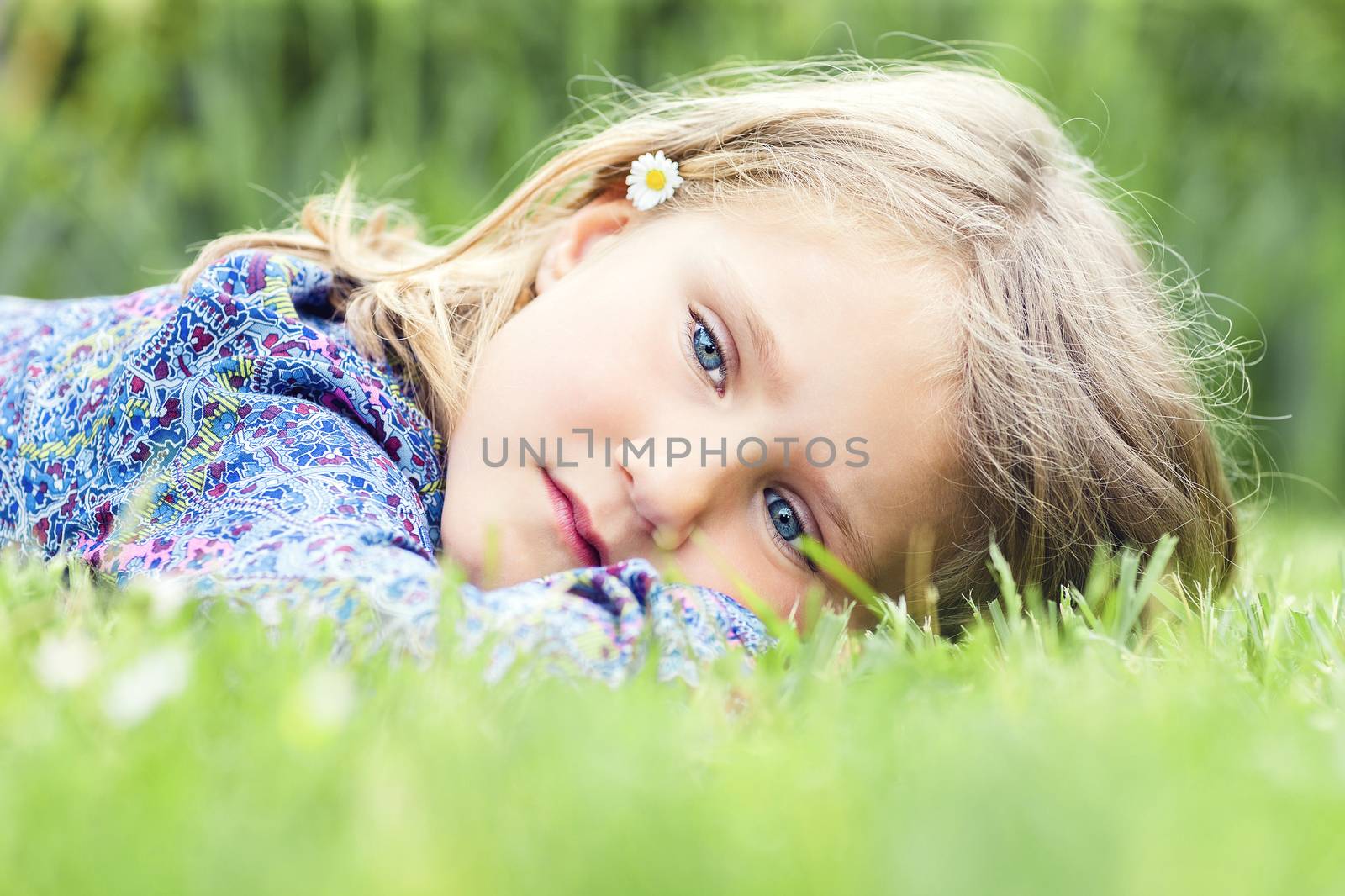 Little adorable girl lying on grass 