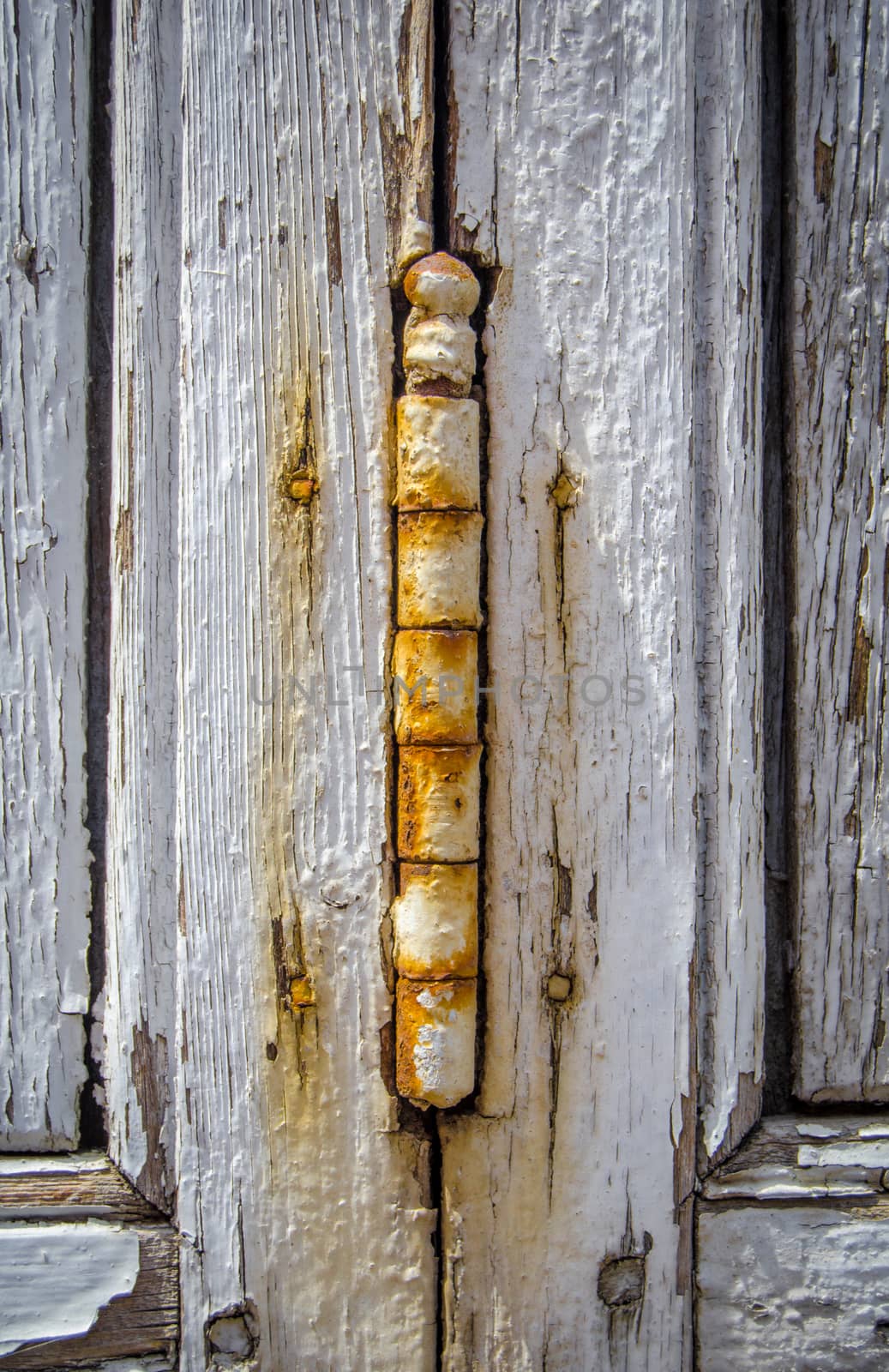 Detail Of A Rusty Hinge On A Weathered Wooden Shutter