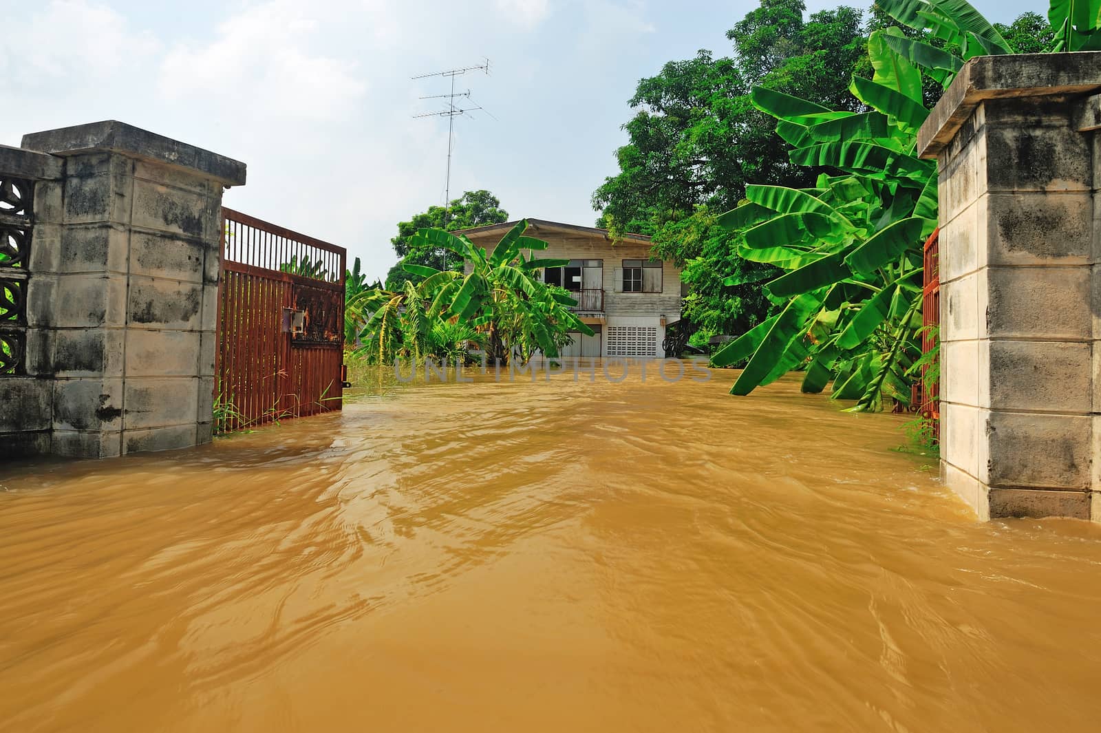 flood waters overtake a house in Thailand by think4photop