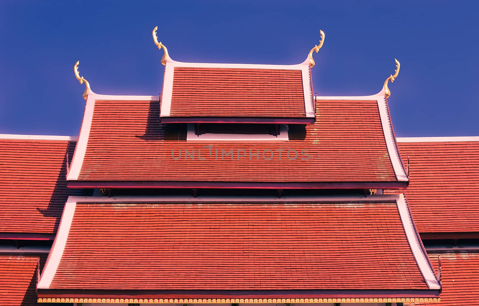 The red tile roof is the architecture of Buddhist temple.It has Naga structure on gable and ornemental roof points shaped like the head of the Garuda (snake).