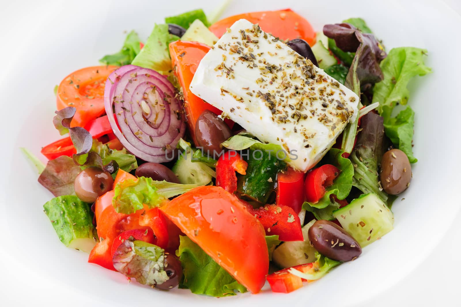 closeup of greek salad with large piece of feta