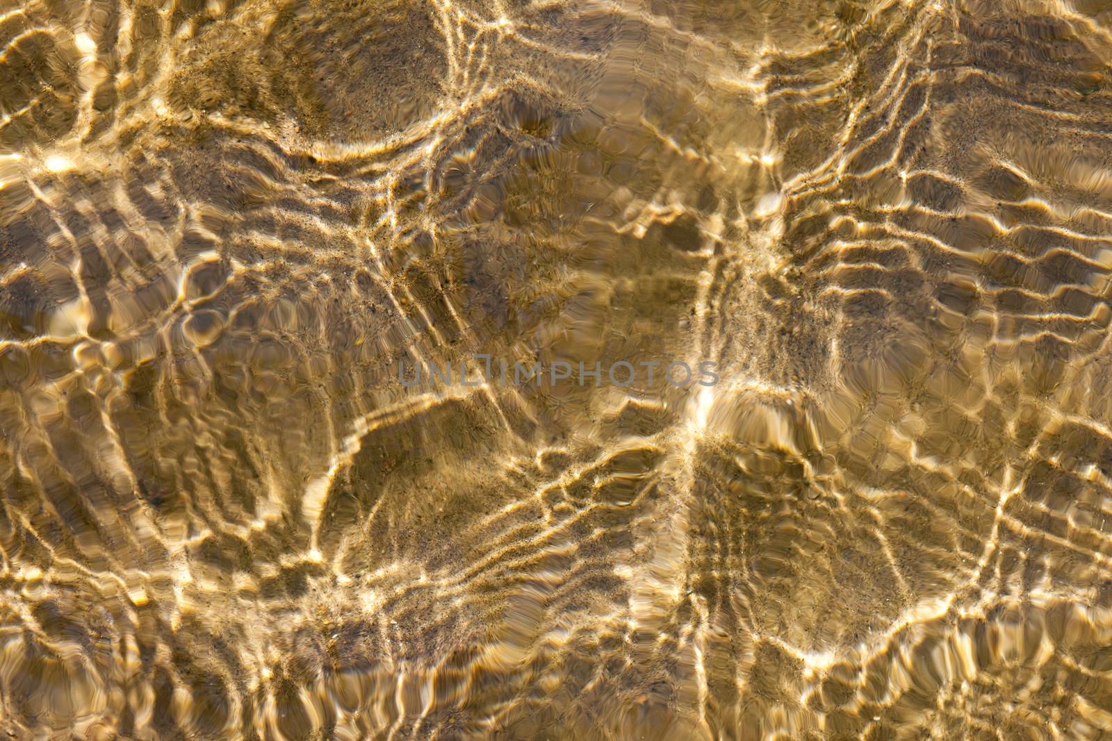 Sunny water ripples over sand by elenathewise