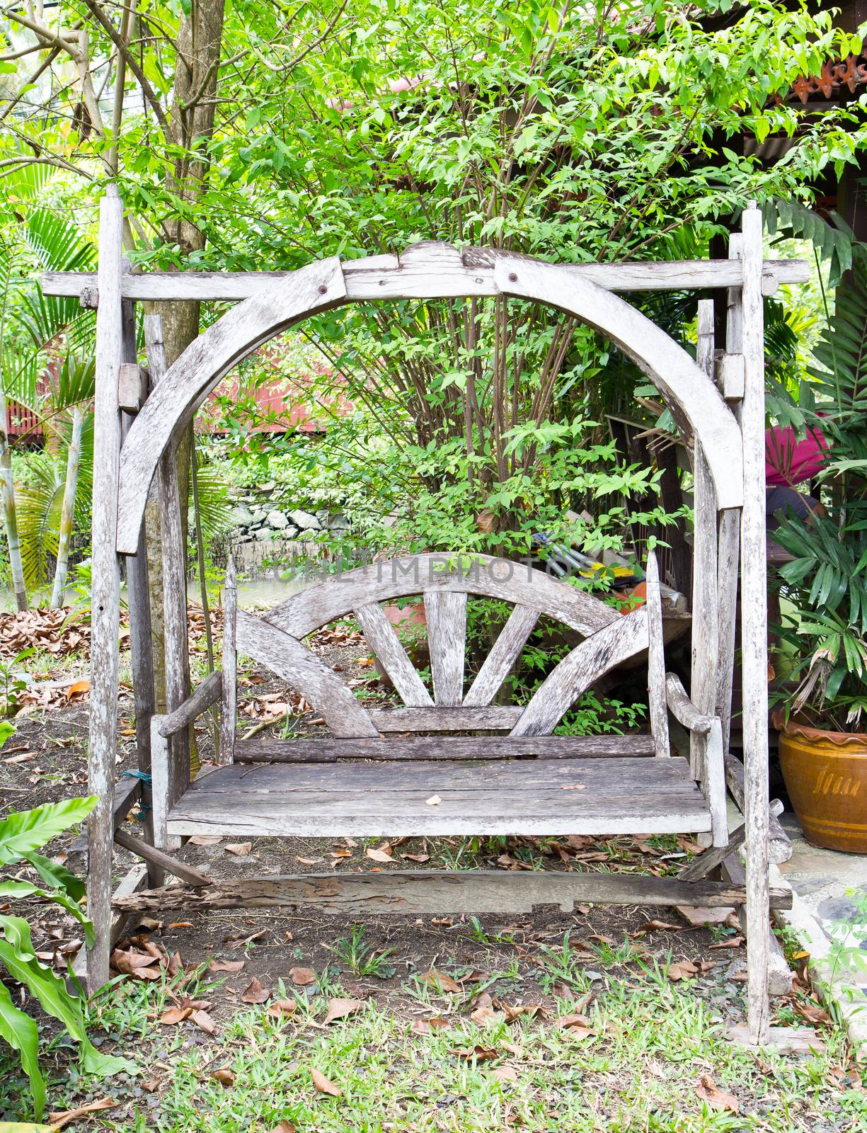 Vintage wooden swing in the garden by tisskananat