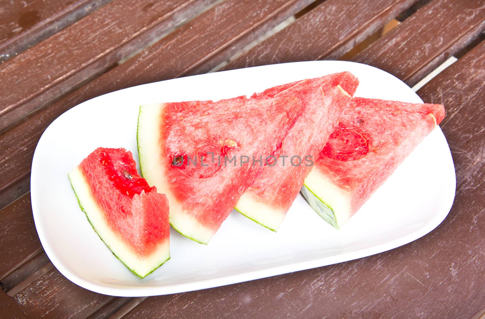 Close-up of fresh slices of red watermelon  by tisskananat