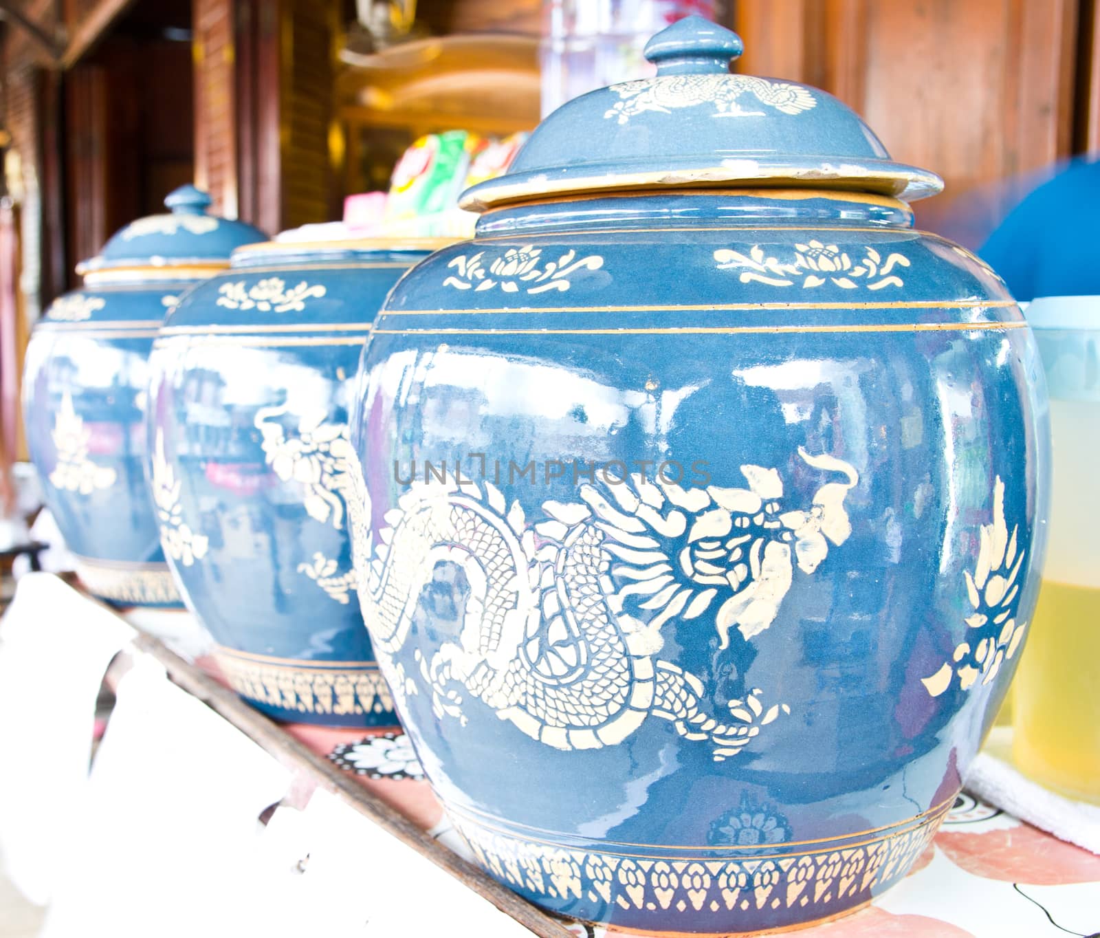 Antique glazed water jar with dragon patterns at home by tisskananat