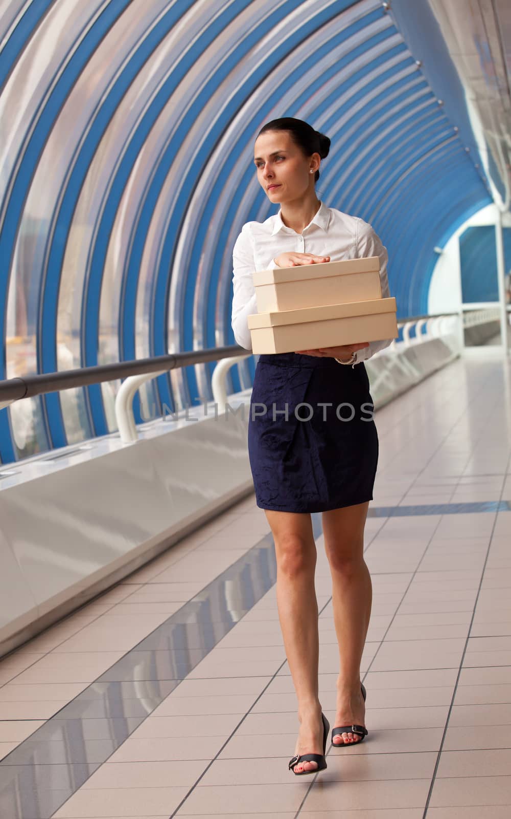 young woman in a white blouse  carries boxes by Astroid