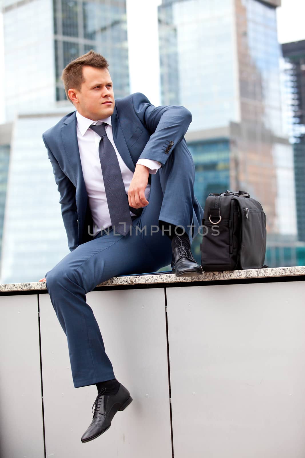 Businessman near office towers by Astroid