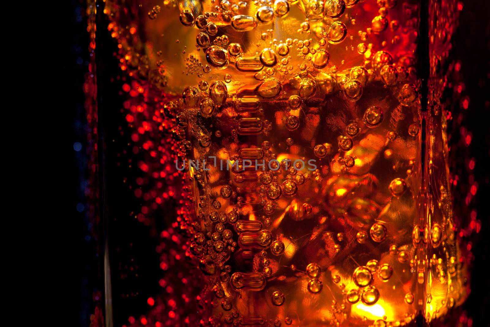 edge of a glass with a drink on the black background