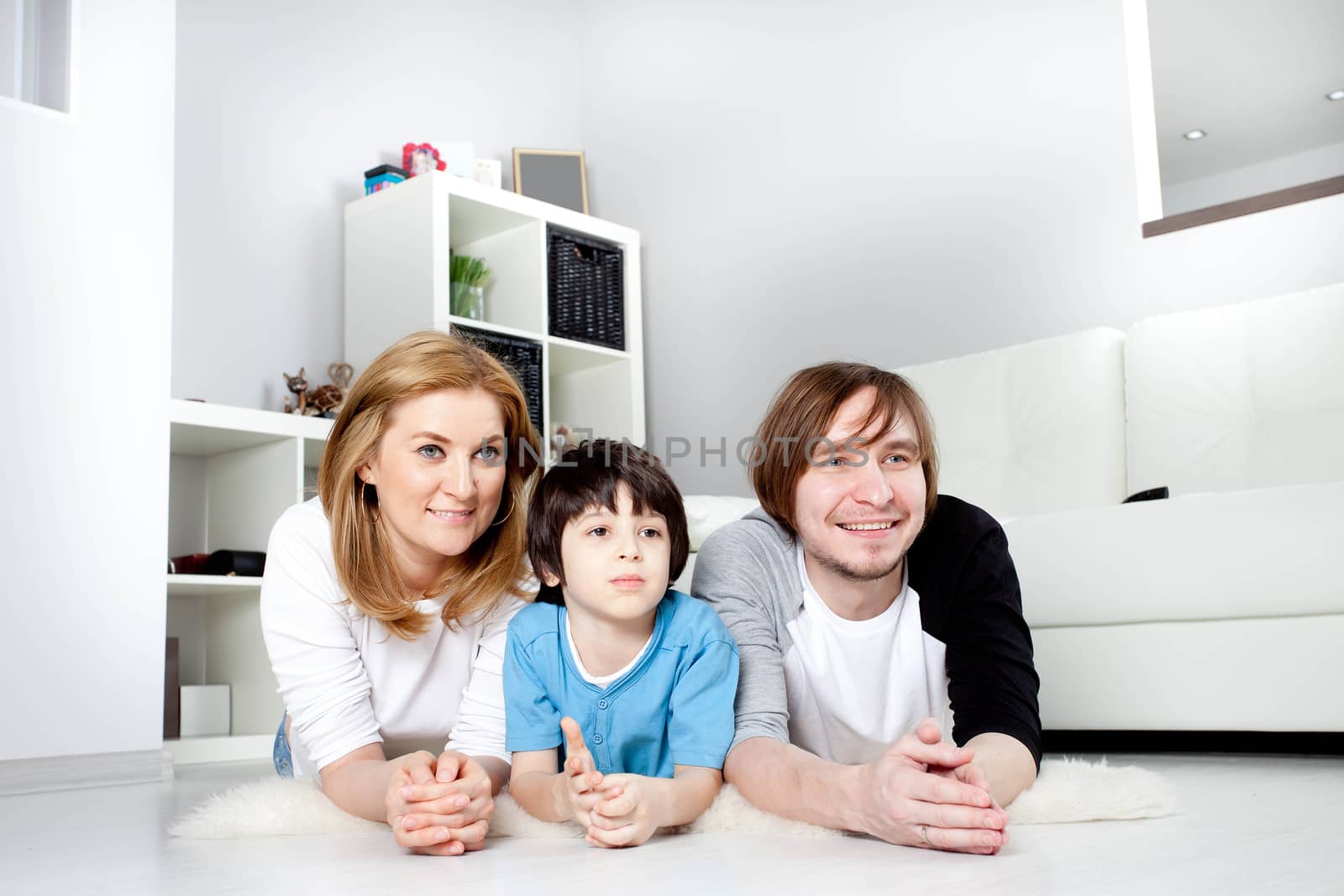 happy family in the interior of a new home watching TV