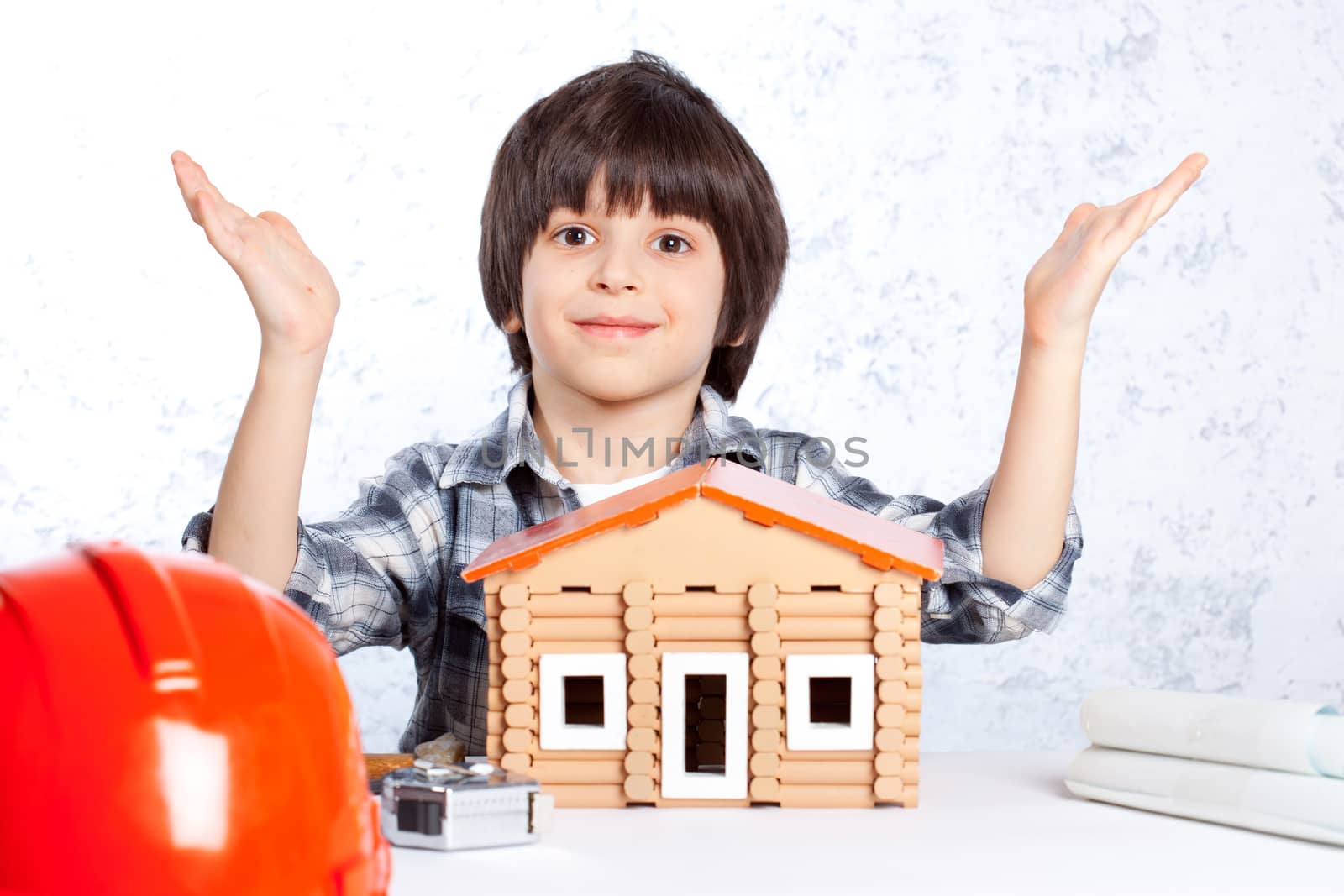 boy built a new house and shows his hands up
