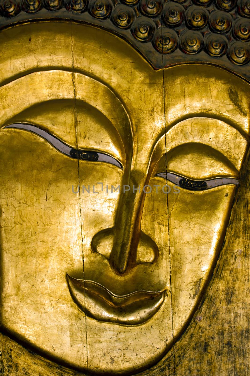 A wooden golden Buddha face.