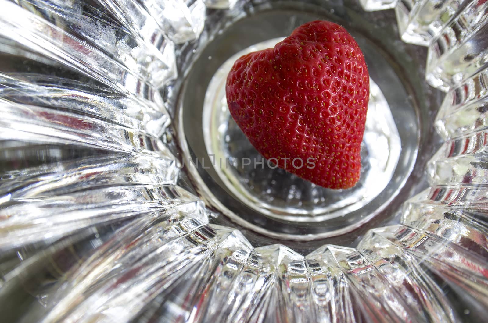 Whole strawberry uncrowned in the shape of heart on abstract background by propaga