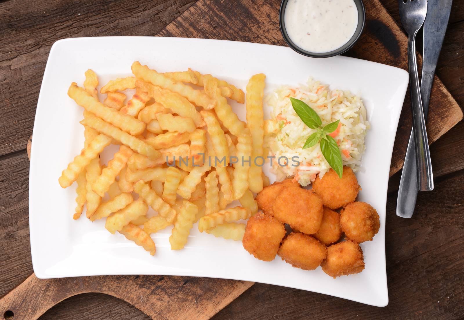 Fries with chicken nuggets and salad