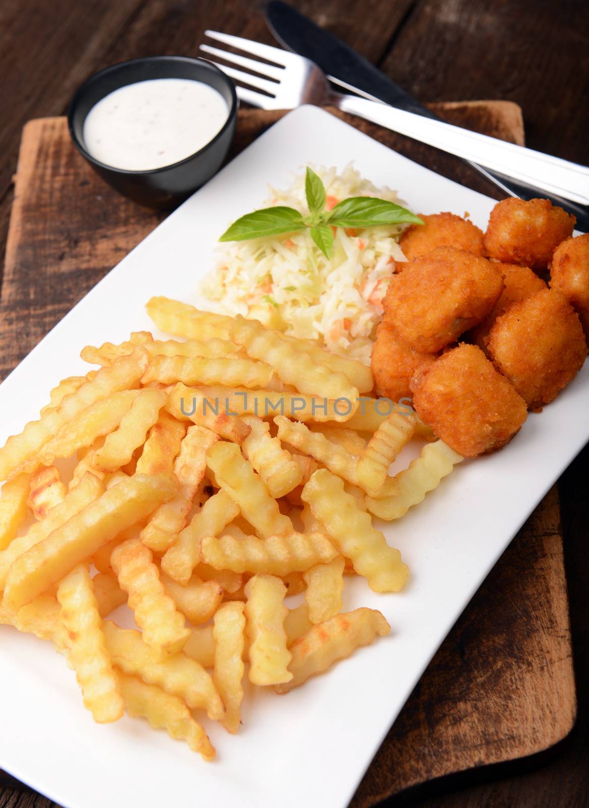 Fries with chicken nuggets and salad